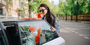 Young woman getting into a car share